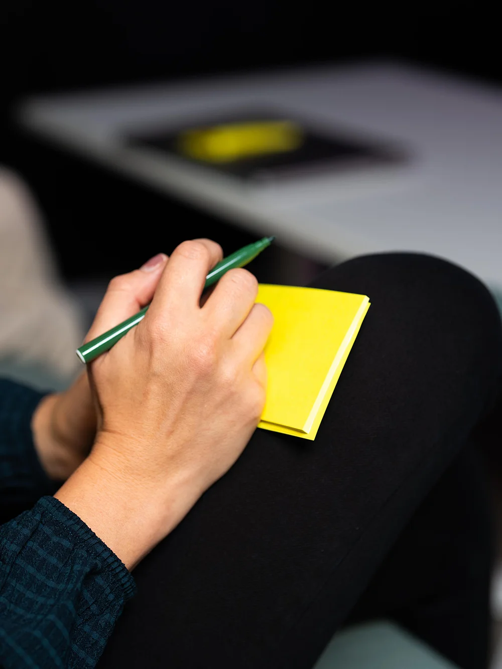 Person holding a pen and sticky notes